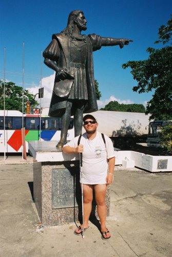 Tony standing by a statue