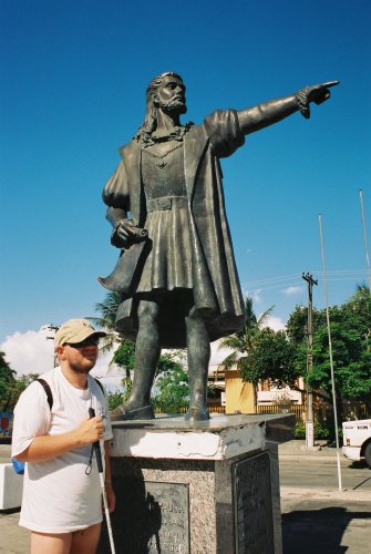 Tony standing by a statue