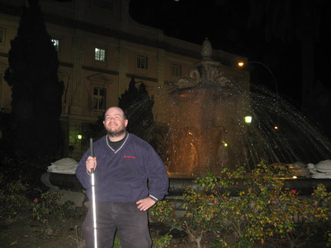 Tony standing in front of a fountain in the centre of Cadiz