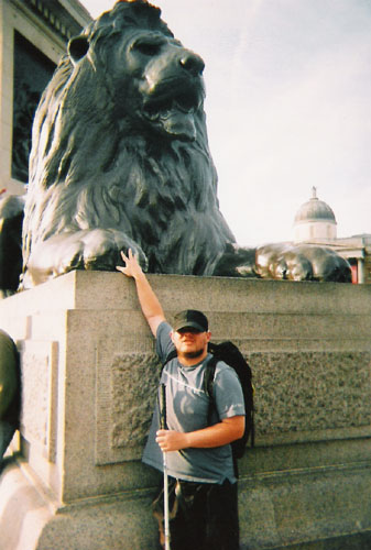 Tony in front of one of the lions in Trafalgar Square